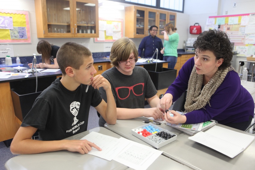 Jen Lee, right, explains a chemistry lab to students.